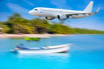 Commercial airplane above sea beach in summer season and clear blue sky over beautiful scenery nature background,concept business travel and transportation summer vacation travel
