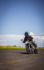 Man riding motorcycle. Motorbike riding on empty road with natural background.