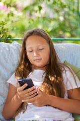 a girl is sitting on the terrace with a gadget