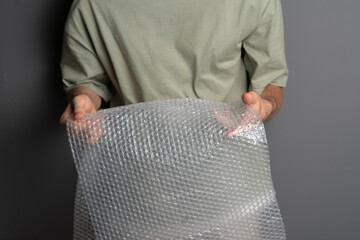 person holding and bursting bubble protective wrap trying to calm down
