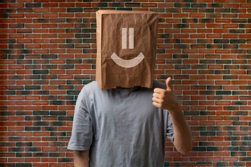 person with thumb up and a happy smile on the paper bag on head