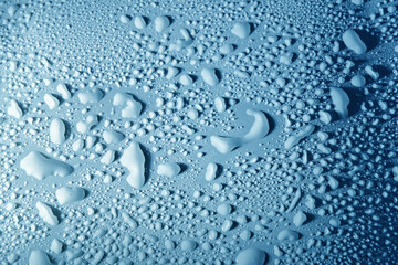Blue drops of water, dew on smooth surface.