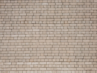View of empty, white brick wall background with copy space. A deteriorating brick wall outdoors in sunlight