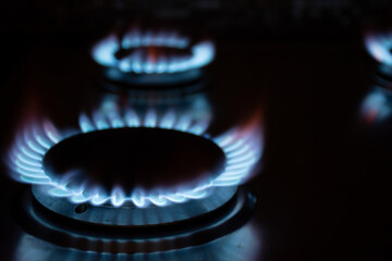 Gas burners burn with a blue flame in the dark