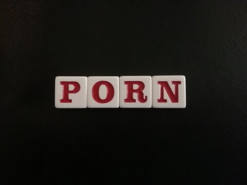 The word Porn is spelled with white and red tiles on a black leather background sheet