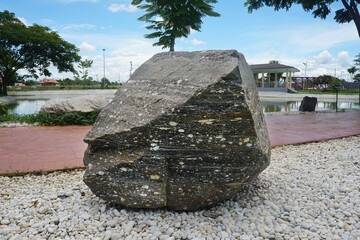 A big gneiss metamorphic rock stone on outdoor garden decoration.