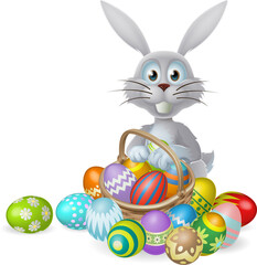 Easter bunny and cWhite Easter bunny rabbit with a basket of colorful chocolate Easter eggshocolate egg basket