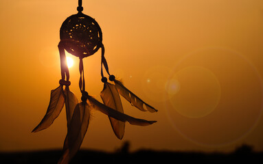 Dreamcatcher with white feather thread and beaded string. Handmade Dreamcatcher.The light of the setting sun.         