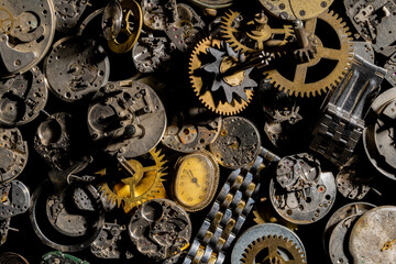Top view of heap of metal internal parts of old clock. Dial, clockwork, bracelet, gears, cogwheels...