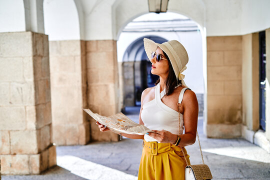 Traveling woman reading map in city