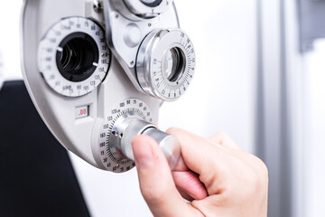Anonymous doctor examining eyes of patient with phoropter