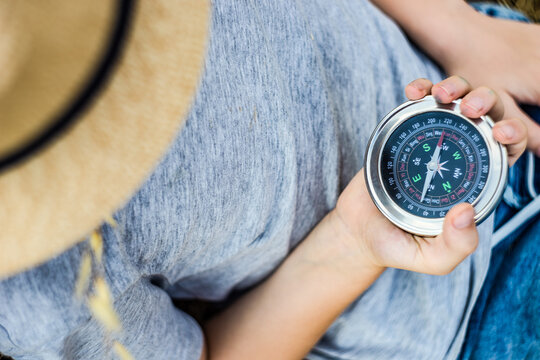 Anonymous boy in the straw hat with compass