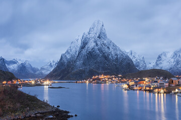 Coastal town near scenic rocky mountains in evening in Norway