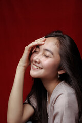 Obraz premium Asian woman taking photo on a red background. Happy Asian woman. Beautiful asian woman with long and straight hair.