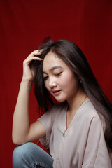 Obraz premium Asian woman taking photo on a red background. Happy Asian woman. Beautiful asian woman with long and straight hair.