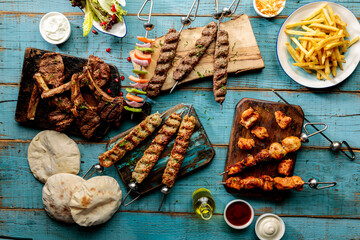 Arabic grills platter with kabab, seekh, tikka, boti, bread, pita, salad and fries isolated on...