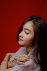 Fototapeta premium Asian woman taking photo on a red background. Happy Asian woman. Beautiful asian woman with long and straight hair.