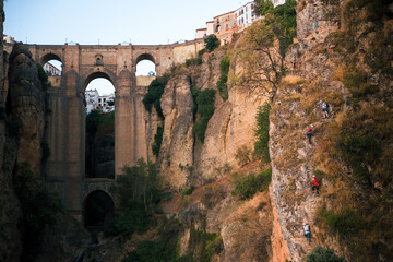 Fototapeta premium People climbing with the Ronda bridge in the background (Ronda, Andalusia, Spain)
