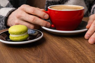 Autumn coffee and desserts close-up. Coffee break outside. Autumn drinks and mood. Flavored coffee. Bright dessert. Eclair. Coffee in male and female hands.