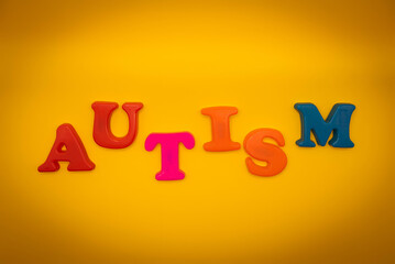 Colorful word AUTISM on yellow background