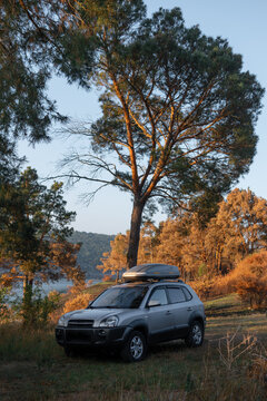 Adventures Camping tourism suv off road vehicle. Background lake, river an mountains. Landscape outdoor in morning, summer day. Roof rack box. Tourism and vacation. Ukraine. Vertical photo