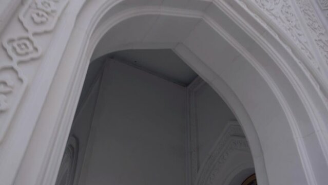 Exterior of a white orthodox beautiful church. Scene. Bottom view of the church building with carved pattern on the walls.