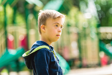 Portrait of a little boy with down syndrome while playing in a park