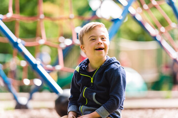 Portrait of a little boy with down syndrome while playing in a park