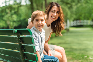 Little boy having great time outside in summer season with his mother