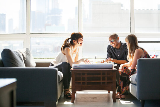 Happy business people discussing about blueprint in creative office - Powered by Adobe