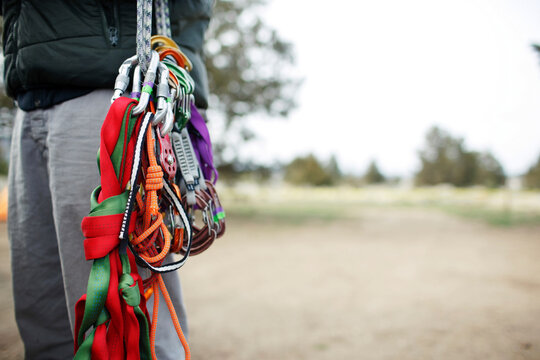 Midsection of man carrying rock climbing equipment on field
