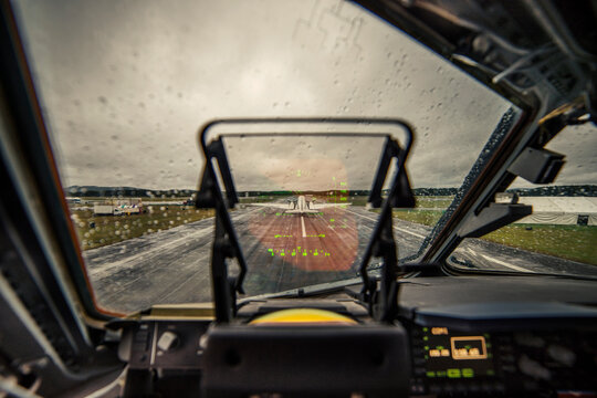 Airplane on runway against sky seen through wet windshield