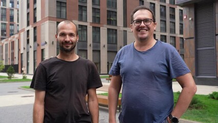 Colleagues or business partners say goodbye and wave their hands at the camera in an urban environment, finishing live video conference