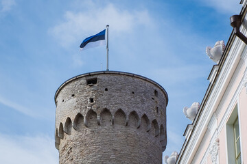 Estonian flag on top of old medieval tower "Pikk Herman" in Tallinn old town. Flag of Estonia - symbol of independence.