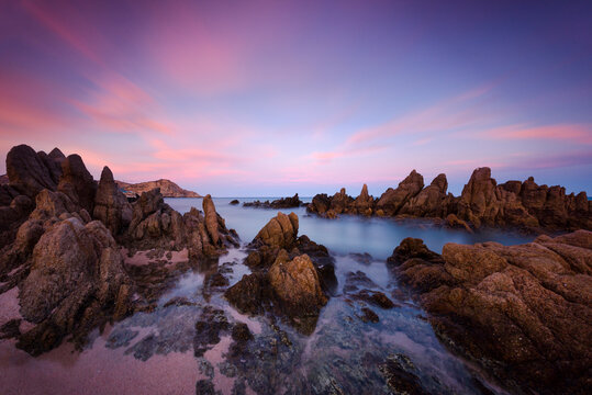 Scenic view of rock formations in sea against dramatic sky