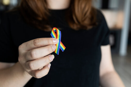 LGBTQ Rainbow ribbon for Support Lesbian, Gay, Bisexual, Transgender and Queer community and Pride month concept. Woman holding rainbow ribbon. 