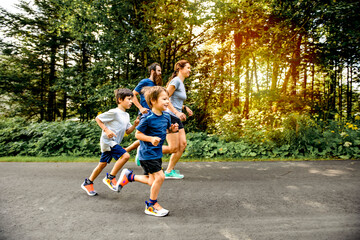 Family exercising and jogging together at an outdoor park - obrazy, fototapety, plakaty