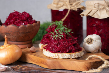 Homemade spicy caviar from beets, carrots, onions and garlic on toasted bread and also in jars on...