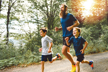father and two sons running outside in forest