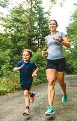 mother and son running outside in forest