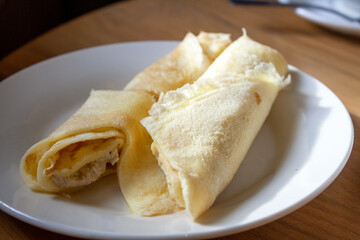 omelet rolls with chicken filling on a plate, with shadow, selective focus, close-up