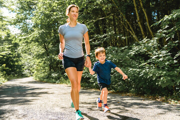 mother and son running outside in forest