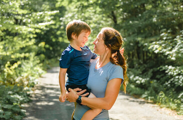 sporty family mothe and son outside in forest