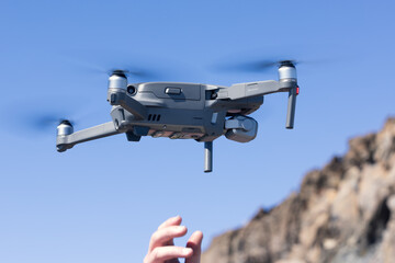 Man Hand launching drone against blue sky