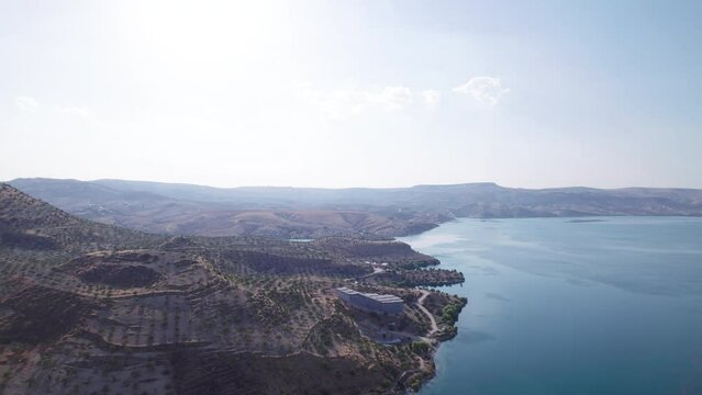 Aerial view of the Birecik dam and water reservoir on Euphrates river near the ruins of the ancient city of Zeugma. Border of Gaziantep and Sanliurfa provinces, Turkiye