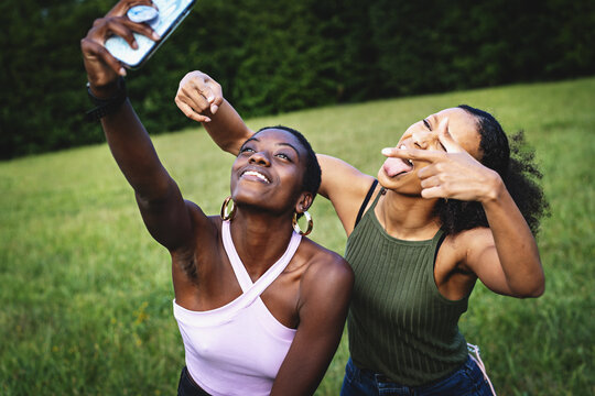 Generation z best friends women taking selfies in the park making faces