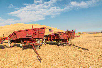 Fototapeta premium Vintage farm wagons used to harvest wheat.