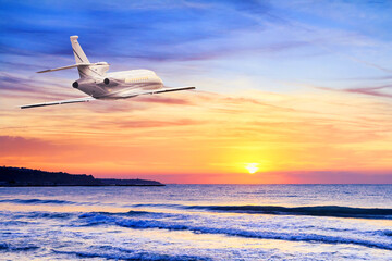 Fototapeta na wymiar Business class airliner during flight against the background of the sunrise over the sea. Photo with free copy space for text