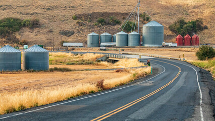 Grain silos along a country road. © Emily_M_Wilson