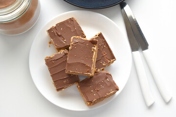 Millionaire's shortbread, caramel shortcake, or millionaire's slice on a white plate.